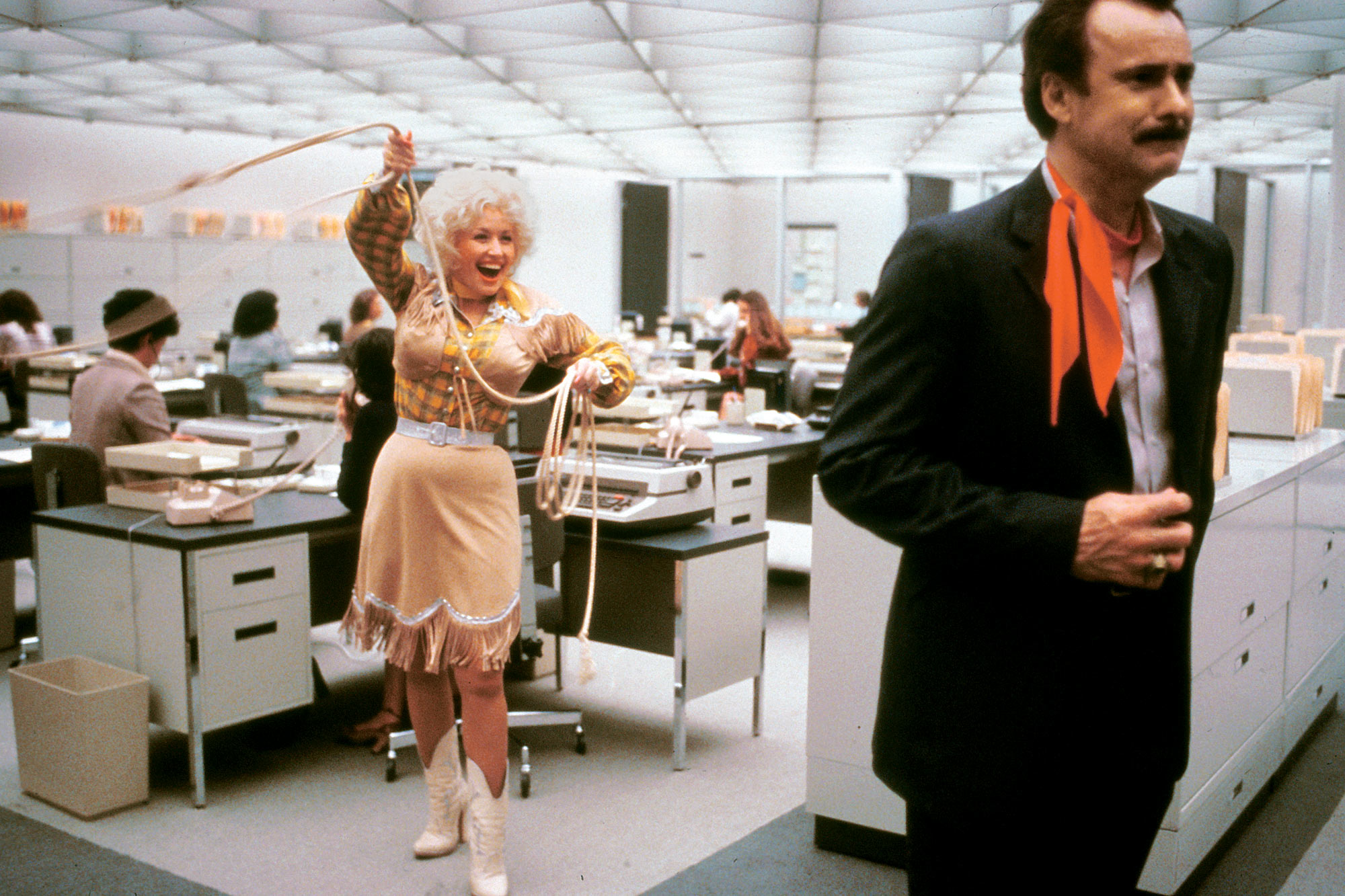 Image from 9 to 5. Showing Dolly Parton's character attempting to lasso another character.